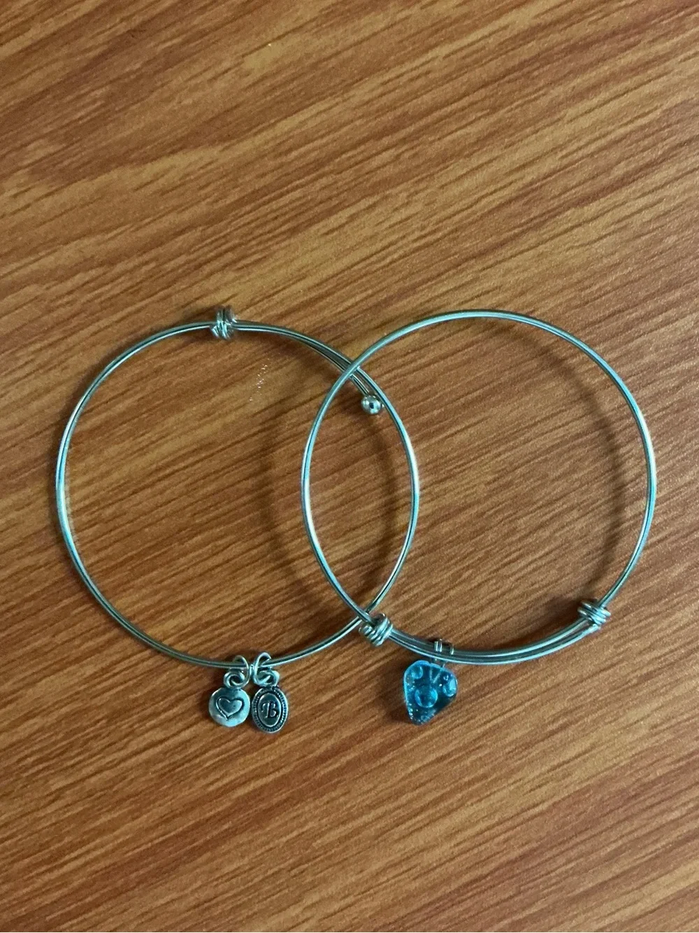 A Brighton silver tone bangle and a no brand bangle with heart shape charm.